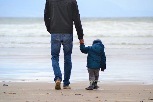 Padre e hijo caminando en la playa